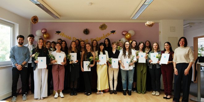 22 Auszubildende bestehen Ergotherapie-Examen Absolventinnen und Absolventen der Ergotherapie Schule Mainz zeigen Ihre Examen in die Kamera.